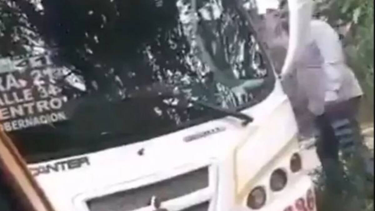 Taxista amenaza con machete a un conductor de bus frente a la mirada de policías